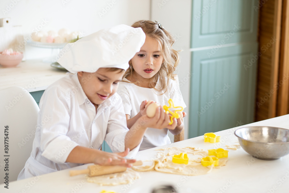 little children bakers on kitchen with baking ingredients