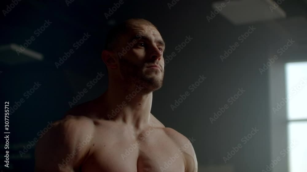 A man without a t-shirt waits and adjusts to the exercise. Expectation. Ready to perform a decisive exercise athlete. A strong man engaged in a gym near the window. A man without a t-shirt waits and adjusts to the exercise. Expectation. Ready to perform a decisive exercise athlete. A strong man engaged in a gym near the window.