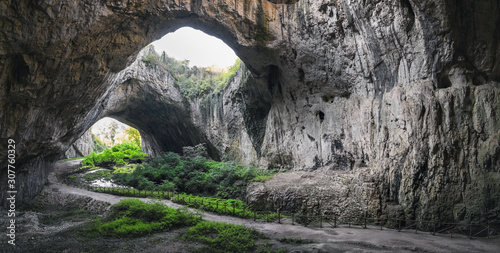 Devetashka cave interior, near Lovech town, Bulgaria. Tunnel of the cave with holes on the top © sonatalitravel