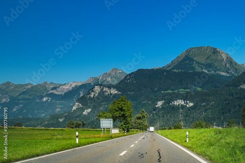 View through the car window to road and natural landscape at foot of Brienzer Rothorn mountain in Bernese Oberland region, Switzerland. Motion blur, selective focus on the center