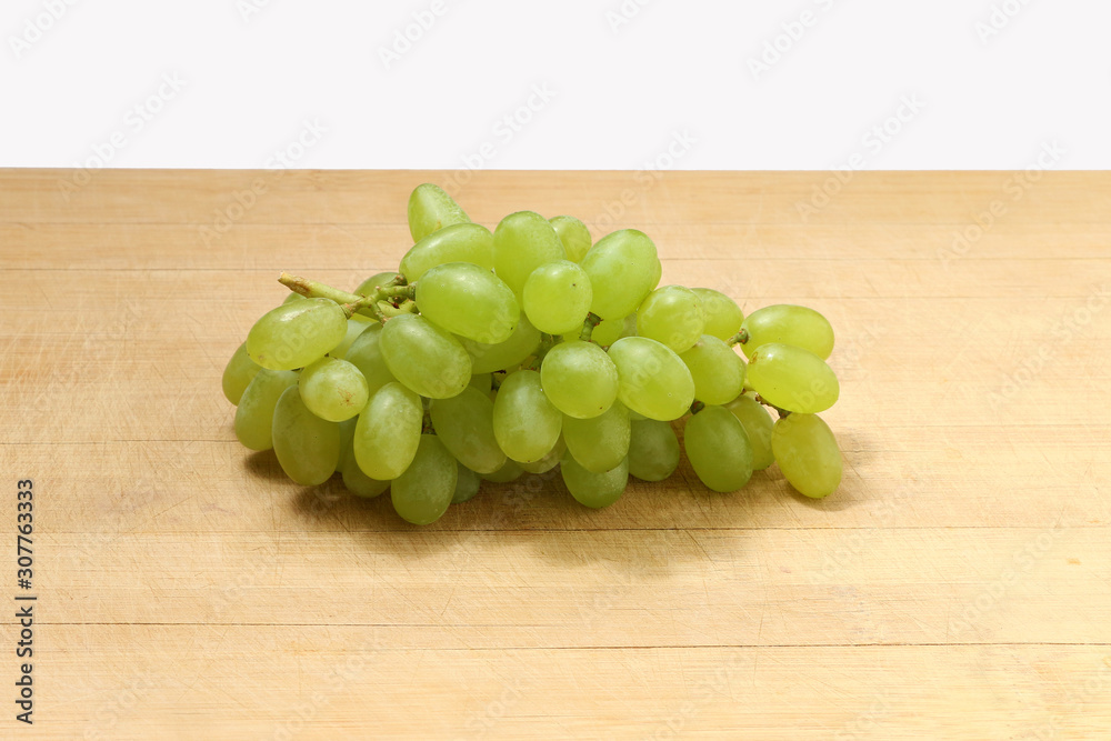 Fresh green grapes fruits . Isolated on wooden background