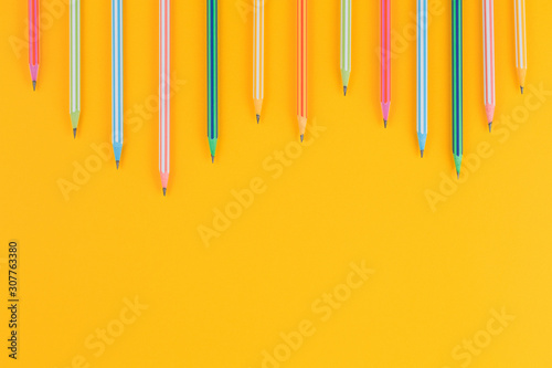 multicolored pencils on yellow isolated background