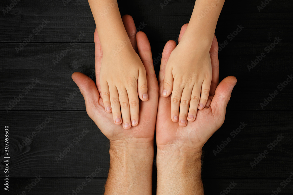 Fototapeta premium Adult hands holding kid hands