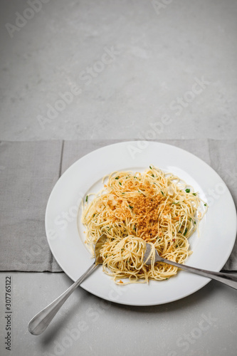 Vegan Spaghetti on white plate; gray napkin on gray countertop