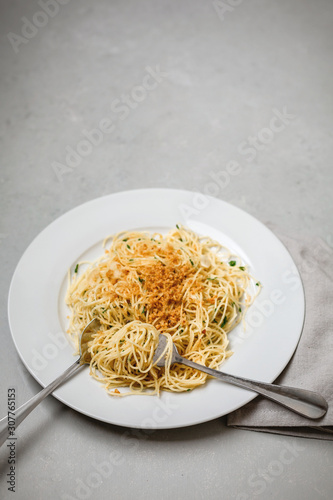 Vegan Spaghetti on white plate; gray napkin on gray countertop