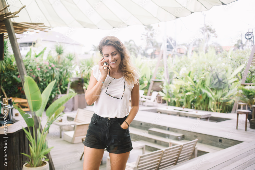 Smiling casual woman chatting on phone on terrace Smiling casual woman chatting on phone on terrace