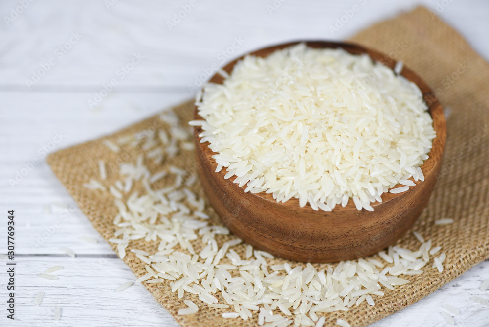 Thai rice white on bowl and sack background - raw jasmine rice grain agricultural products for food in Asian Thai rice white on bowl and sack background - raw jasmine rice grain agricultural products for food in Asian