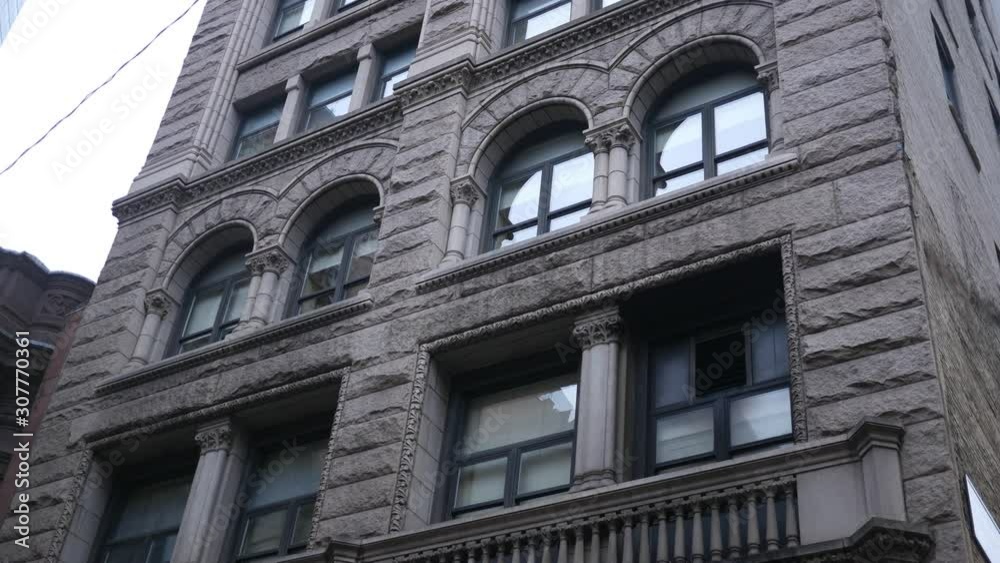 Establishing shot of second story windows of office building in downtown city area overcast day Establishing shot of second story windows of office building in downtown city area overcast day