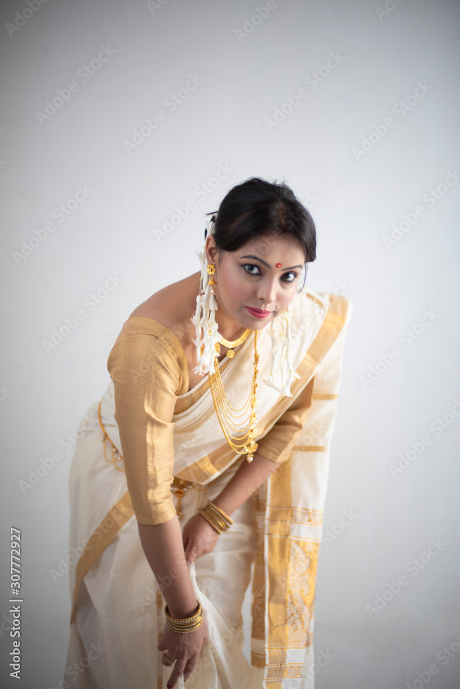 Portrait of an young and attractive Indian woman in white traditional ...