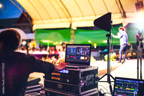 фотографія Sound engineer control music sound and light in concert near the stage