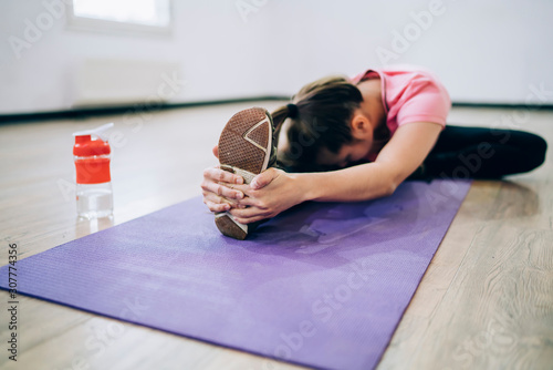 Thin female exercising on yoga mat
