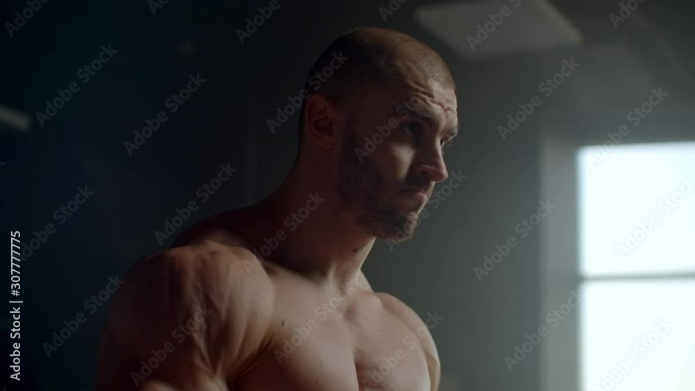 Strong athletic man lifts weights training of the trapezoid muscles Strong athletic man lifts weights training of the trapezoid muscles