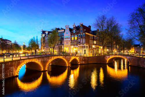 Canals of Amsterdam during twilight in Netherlands. Amsterdam is the capital and most populous city of the Netherlands. Landscape and culture travel, or historical building and sightseeing concept.