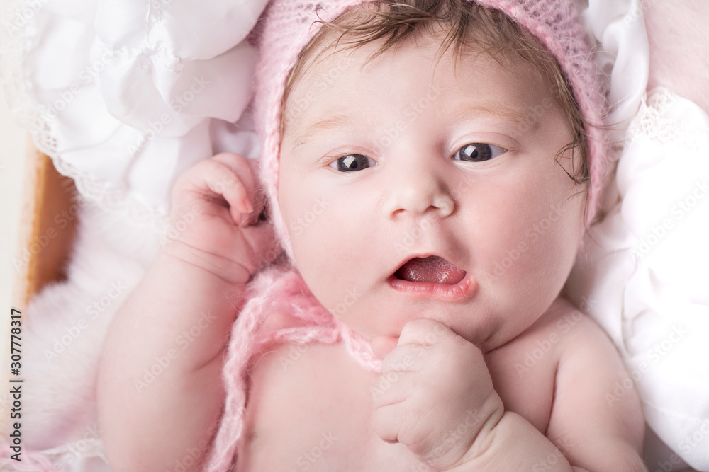 Newborn baby girl with mouth open in pink bonnet Newborn baby girl with mouth open in pink bonnet