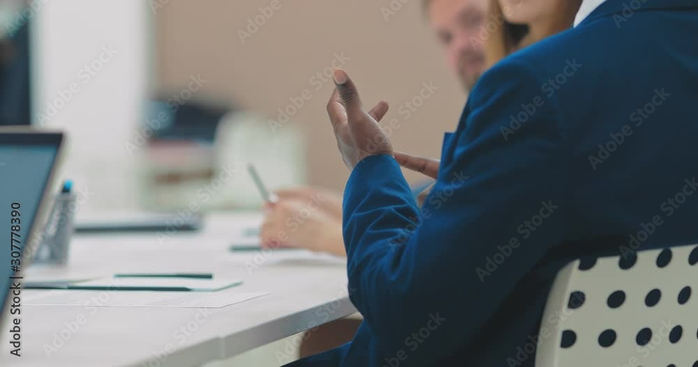 Black employee gestures at a meeting, business office. Hands, close-up.
