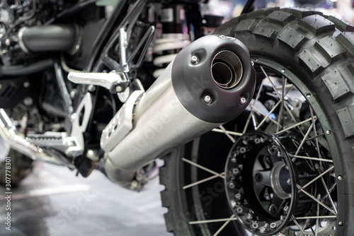 Close-up of exhaust or Intake of black sport racing Motorcycle with new tire and wheel in showroom. Low Angle Photograph Of Motorcycle..