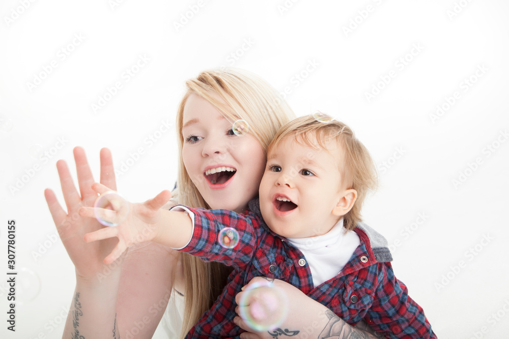 Blowing bubbles, mother and son on white background Blowing bubbles, mother and son on white background