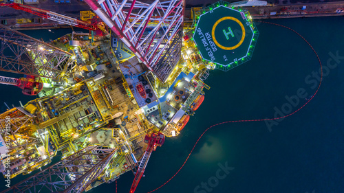 Aerial view construction offshore jack up rig drill at night, Offshore crane crude oil rig drilling platform. photo