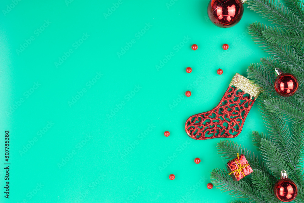 Christmas holidays composition, top view of red Christmas sock and decorations on green background with copy space for text. Flat lay, winter, postcard template, new year concept.