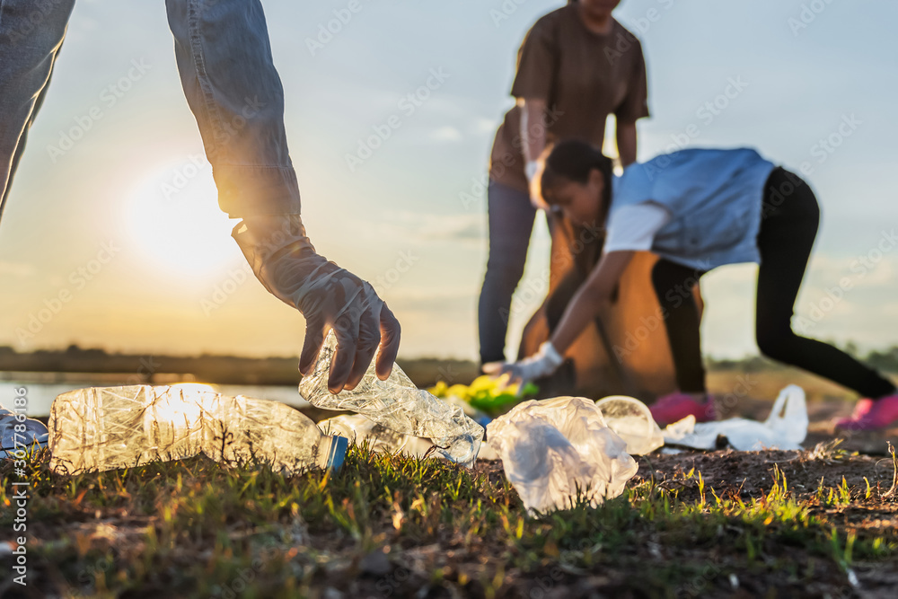 people volunteer keeping garbage plastic bottle into black bag at park ...