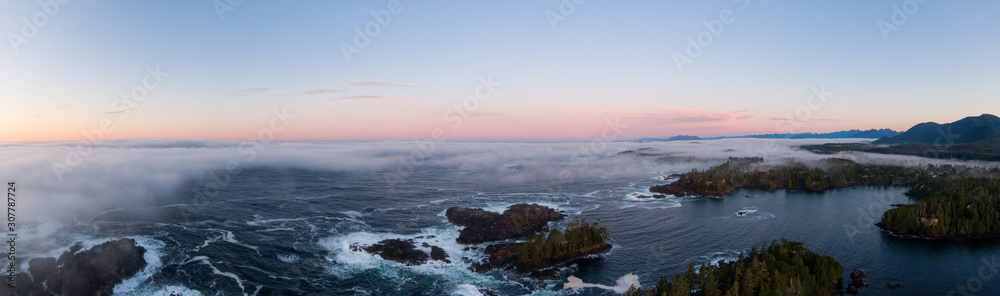 Fototapeta premium Ucluelet, Vancouver Island, British Columbia, Canada. Aerial Panoramic View of a Small Town near Tofino on a Rocky Pacific Ocean Coast during a cloudy and colorful morning sunrise.