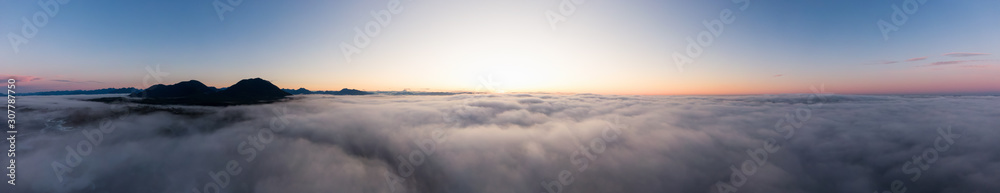 Aerial Panoramic View of Pacific Ocean Coast Covered in Fog and Clouds during a colorful sunny sunrise. Taken in Vancouver Island, BC, Canada near Tofino and Ucluelet. Aerial Panoramic View of Pacific Ocean Coast Covered in Fog and Clouds during a colorful sunny sunrise. Taken in Vancouver Island, BC, Canada near Tofino and Ucluelet.
