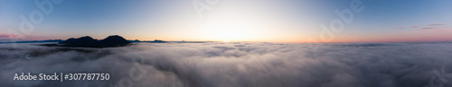 Aerial Panoramic View of Pacific Ocean Coast Covered in Fog and Clouds during a colorful sunny sunrise. Taken in Vancouver Island  BC  Canada near Tofino and Ucluelet.