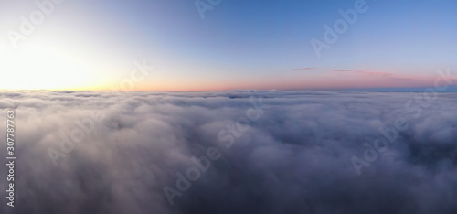 Fototapeta Naklejka Na Ścianę i Meble -  Aerial Panoramic View of Pacific Ocean Coast Covered in Fog and Clouds during a colorful sunny sunrise. Taken in Vancouver Island, BC, Canada near Tofino and Ucluelet.