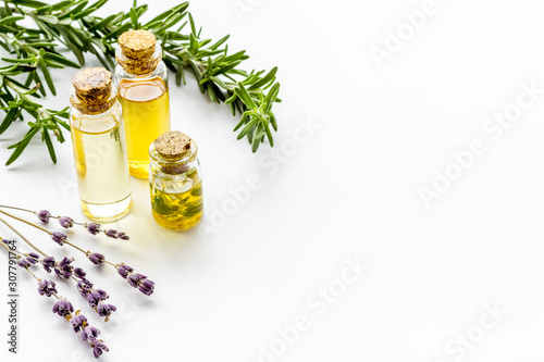 Aromatherapy. Essential oils in small bottles near fresh herbs on white background copy space