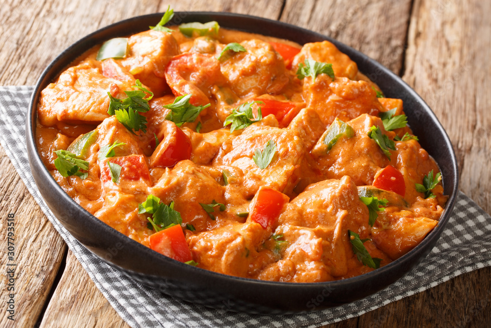 Mafe is a famous and popular West African dish cooked chicken in spicy peanut sauce close-up in a plate. horizontal