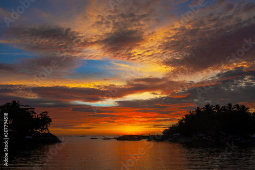Amazing colorful sunset before an typhoon over coastal landscape with an lagoon in the foreground at Malandog on Panay island in the Philippines