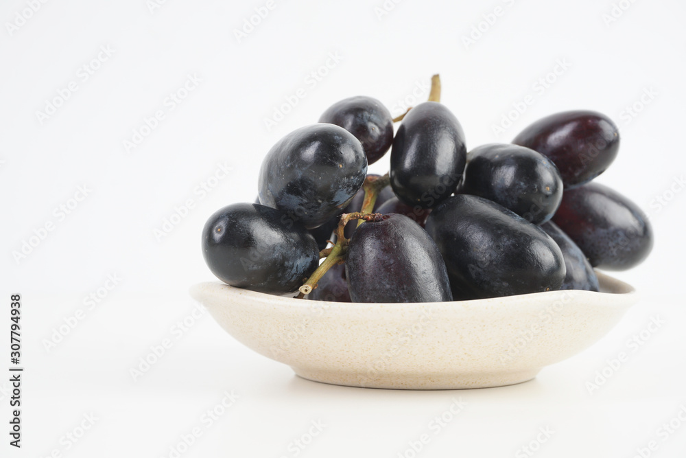 Fresh grape fruits plated over the white background Fresh grape fruits plated over the white background