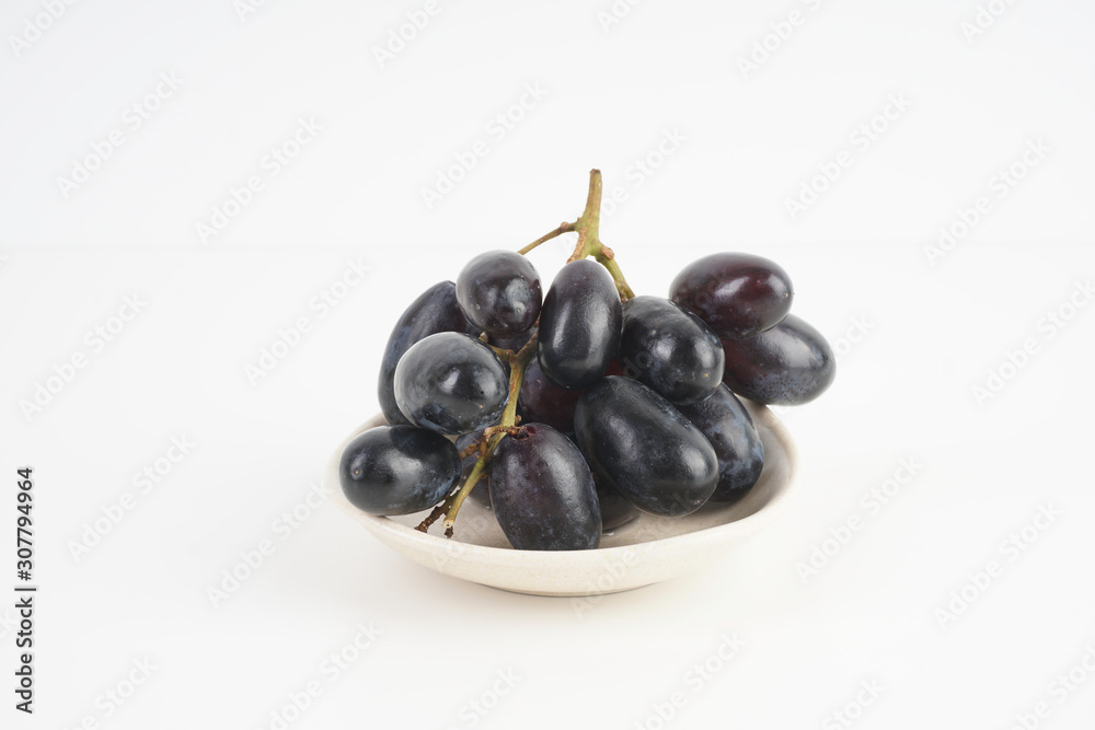 Fresh grape fruits plated over the white background Fresh grape fruits plated over the white background