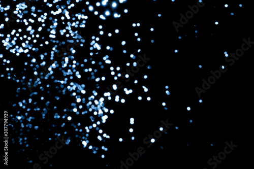Black background with classic blue bokeh lights. Holiday, Christmas and New Year background. Horizontal