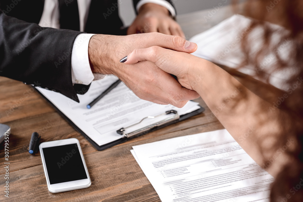 Job Interview. Employer shaking hands with candidate sitting in office close-up Job Interview. Employer shaking hands with candidate sitting in office close-up