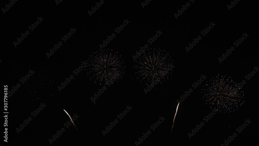 Golden big shiny fireworks with bokeh lights in the night sky. Glowing firework show. New Year's Eve fireworks celebration. Fireworks Festival. Golden big shiny fireworks with bokeh lights in the night sky. Glowing firework show. New Year's Eve fireworks celebration. Fireworks Festival.