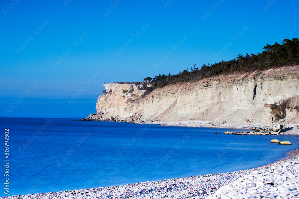 Coastal landscape with high limestone cliff in the background  on the island of Gotland in Sweden