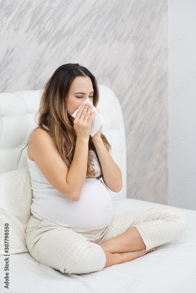 beautiful pregnant woman blowing her nose in a napkin beautiful pregnant woman blowing her nose in a napkin
