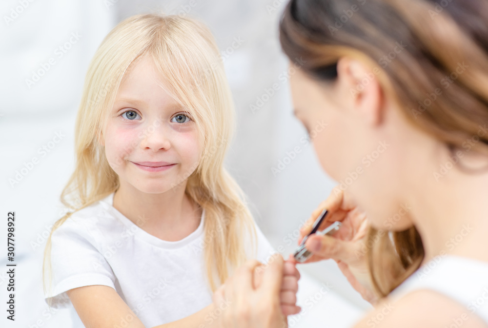 Mother clipping her fingernails to child Mother clipping her fingernails to child