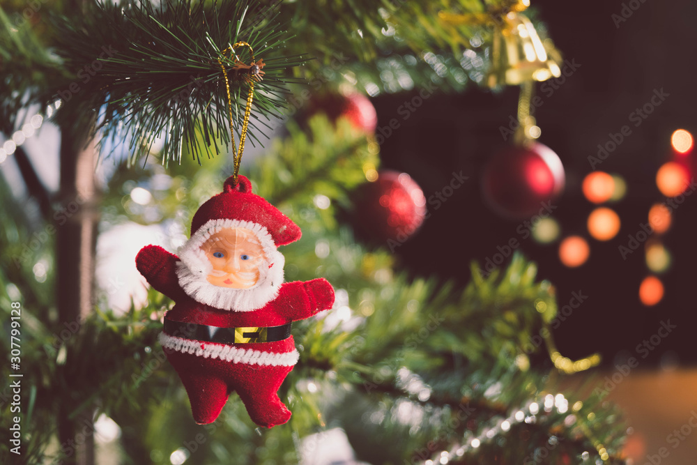 Obraz premium Santa Claus doll Hanging on the Christmas tree to decorate the Christmas or New Year's Eve. There is space for the copy space.