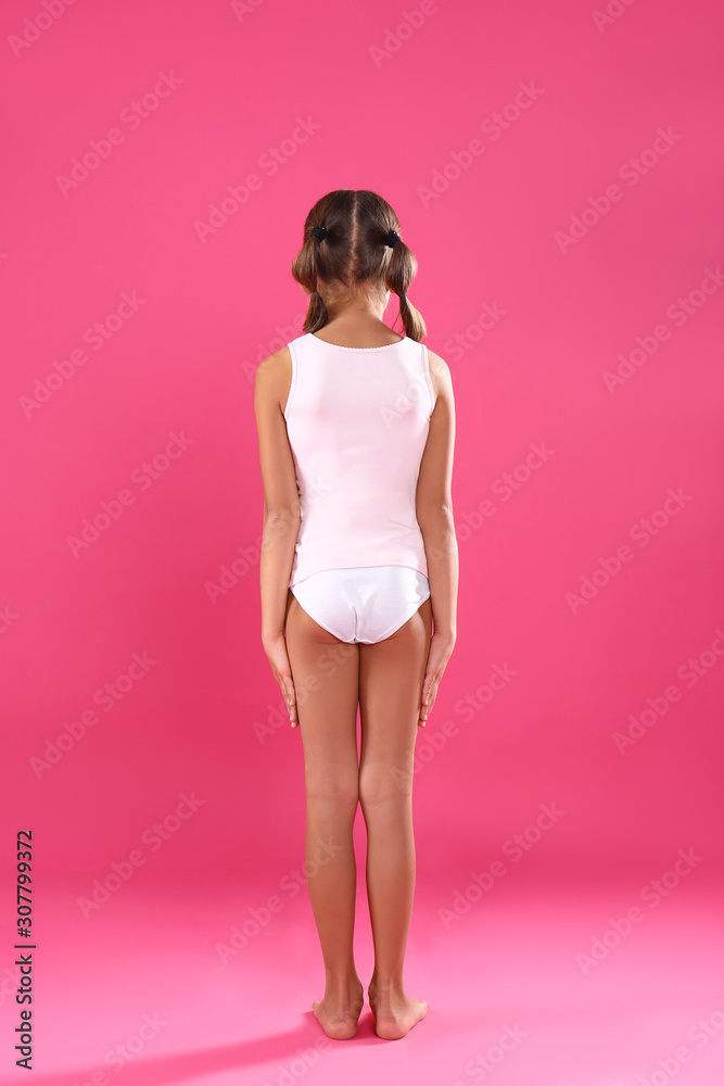 Little girl in underwear on pink background, back view фотография Stock