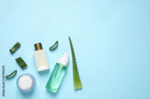 Flat lay composition with aloe vera and cosmetic products on light blue background. Space for text
