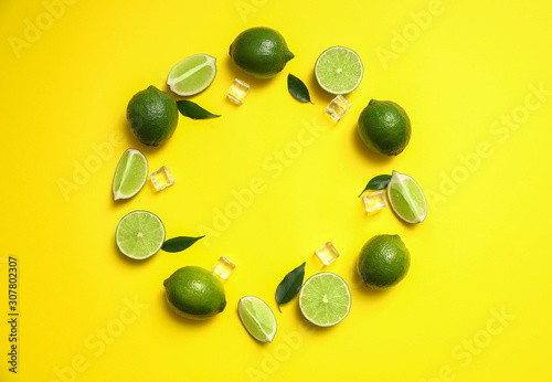Flat lay composition with fresh juicy limes and ice cubes on yellow background. Space for text