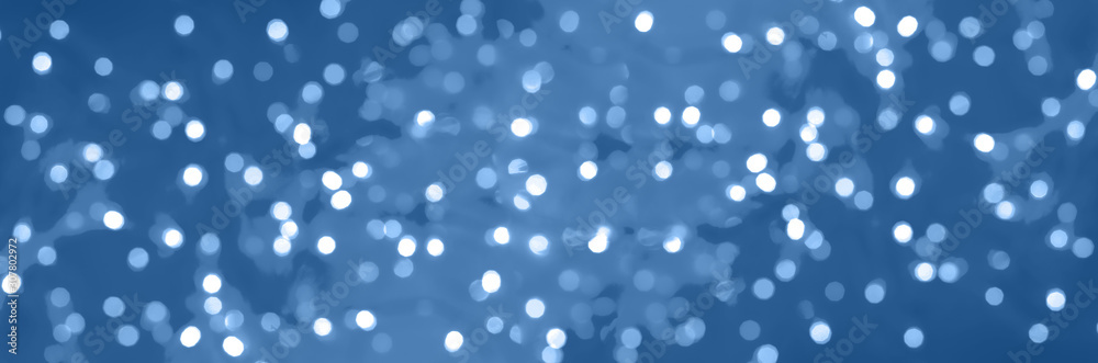 Festive glittering christmas lights. Abstract cement concrete background in trendy monochrome and calm color. Blurred banner with bokeh.