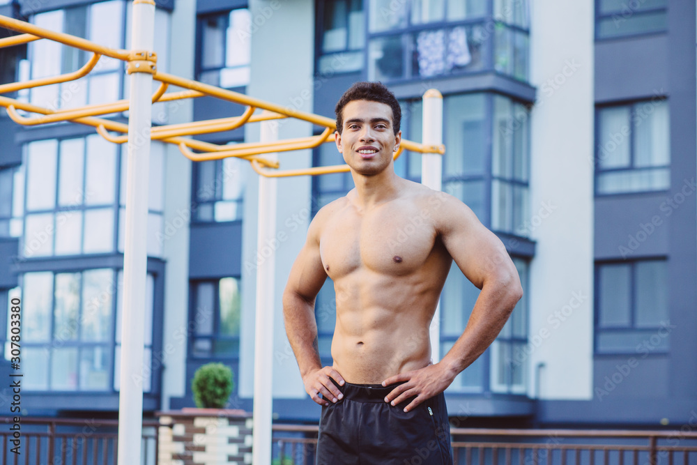 Obraz premium Sportsman resting on sportsground after workout. Athlete man looking away, relaxinf after exercises. Sport, lifestyle and people concept.