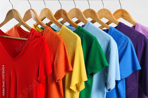 Colorful clothes on hangers against white background