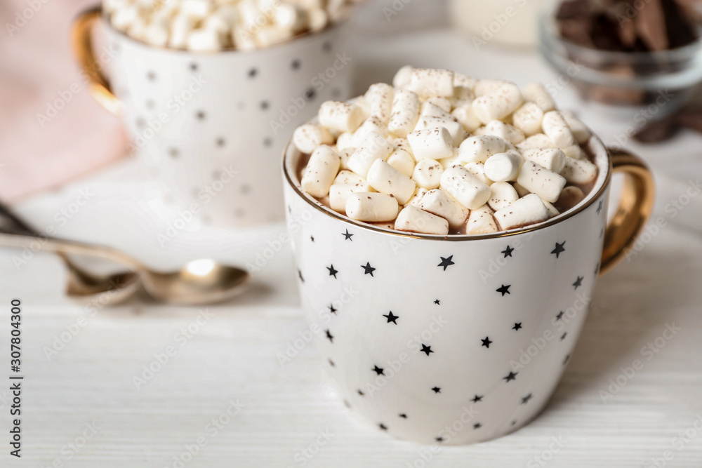 Delicious cocoa drink with marshmallows in cup on white wooden table, space for text Delicious cocoa drink with marshmallows in cup on white wooden table, space for text