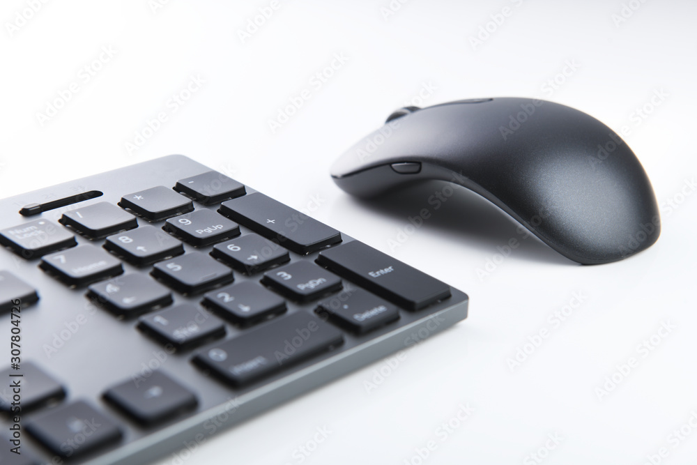 Wireless gray keyboard and mouse on a white background close-up. Wireless gray keyboard and mouse on a white background close-up.