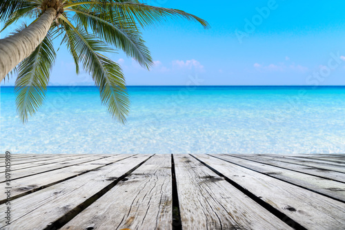 Fototapeta Naklejka Na Ścianę i Meble -  Wooden floor or plank on sand beach in summer. For product display.Calm Sea and Blue Sky Background.