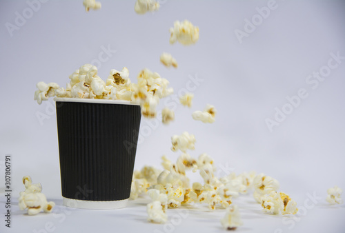 Fototapeta Naklejka Na Ścianę i Meble -  falling popcorn from above in a black textured popcorn box on a white background